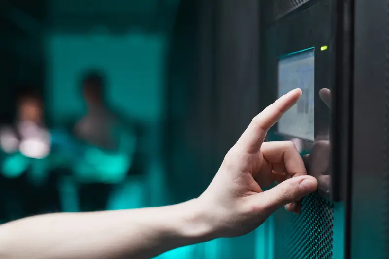 A hand using an access control keypad at a door